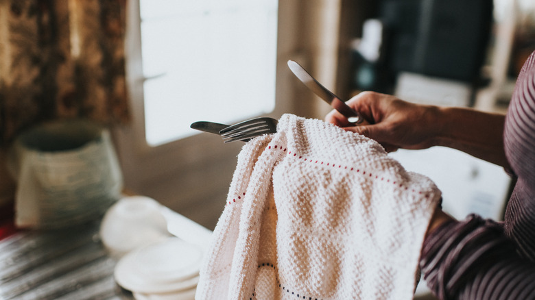 Wiping dishes with a towel