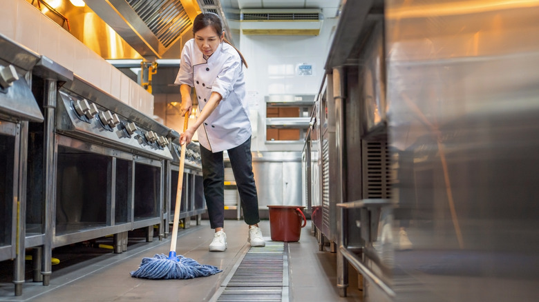 Restaurant worker mopping kitchen floor