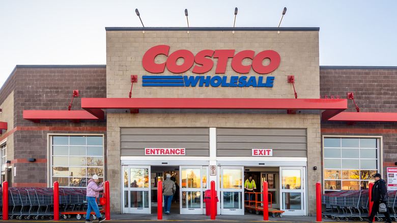 Front entrance of a Costco with light and dark brown brick a red trim