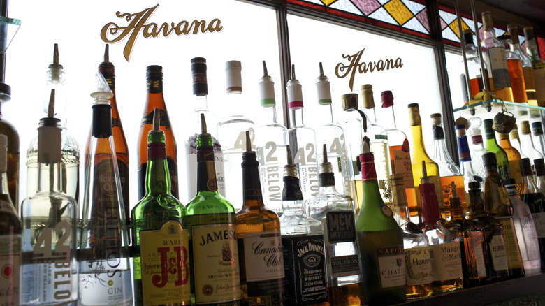 Open bottles of assorted liquor sitting in a bar window