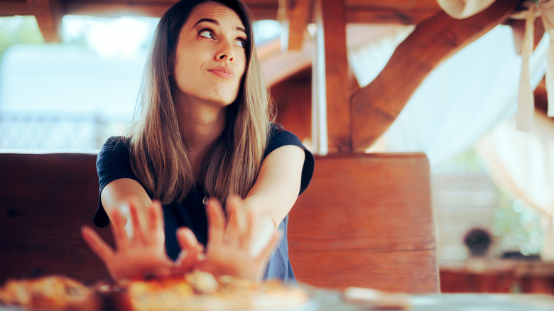 A customer pushing a plate of food away.