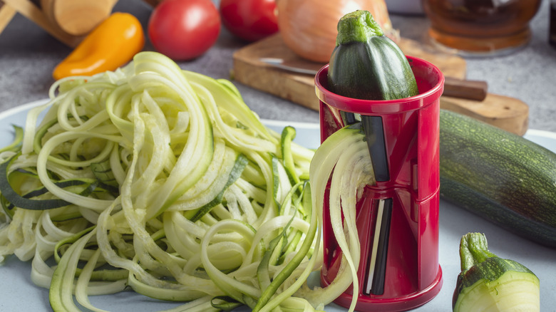 a spiralizer making zoodles near other vegetables