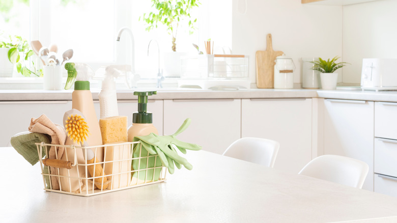 Various eco-cleaning products in a basket on a kitchen counter