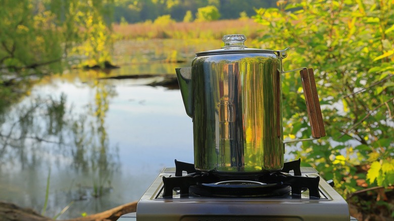 Stainless steel coffee percolator brewing coffee outdoors