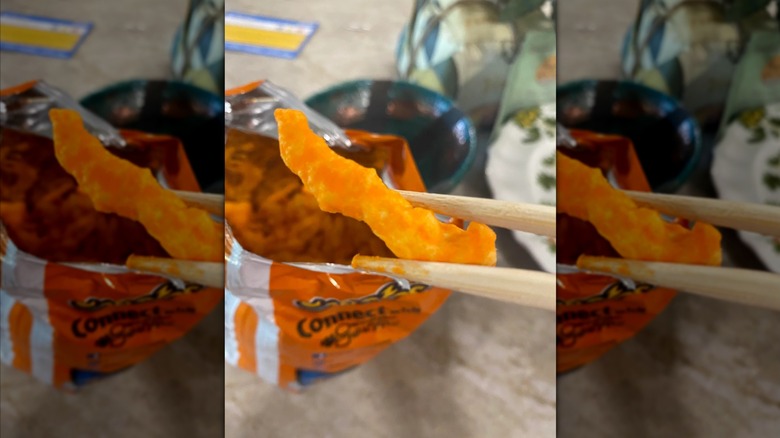 Someone using chopsticks to snack on Cheetos, mirrored