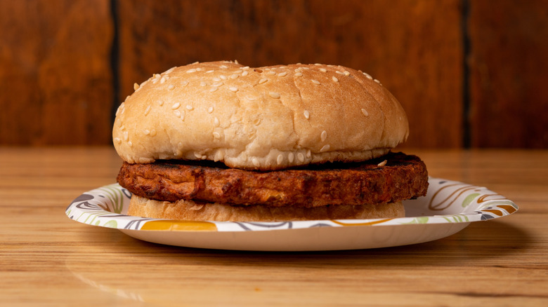 Burger with meat and bread on paper plate