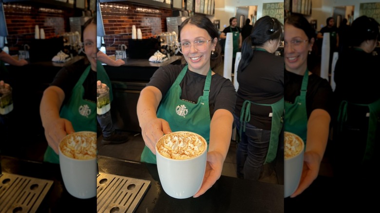 Barista holding out a Pumpkin Spice Latte
