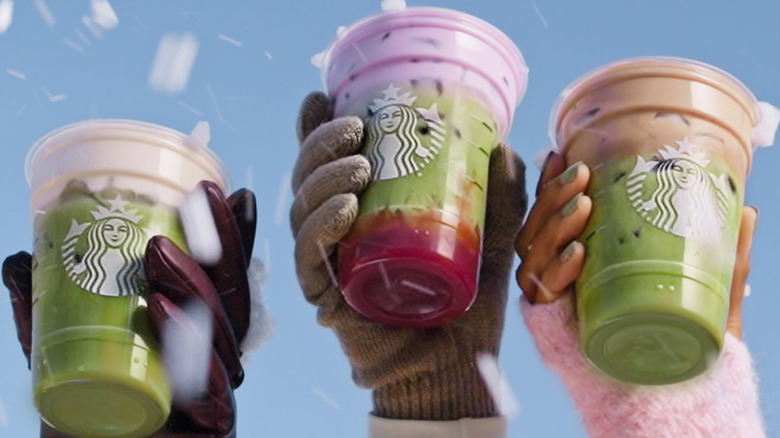 Hands holding Starbucks matcha drinks