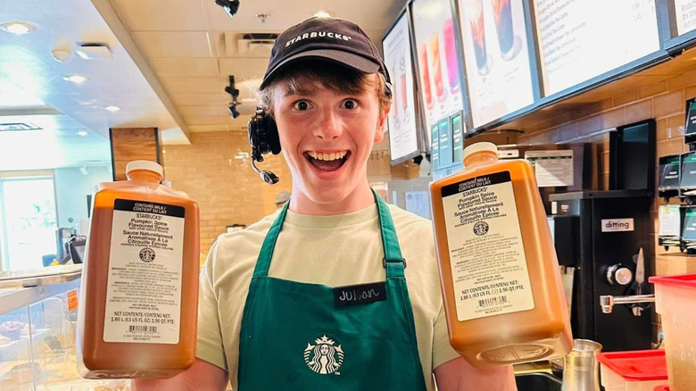 Starbucks barista holding jugs of sauces