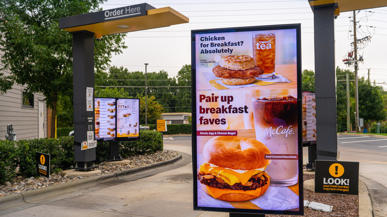 McDonald's drive-thru with a breakfast advertisement in front.