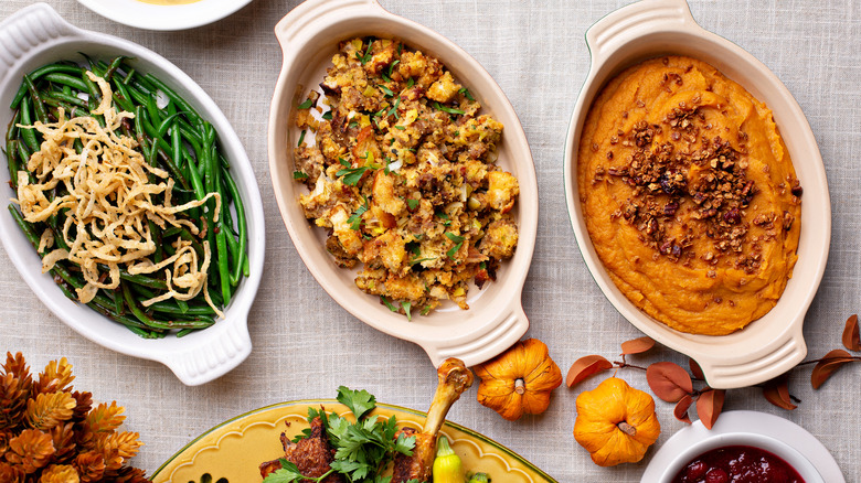 Thanksgiving side dishes including green beans, stuffing, and mashed sweet potatoes