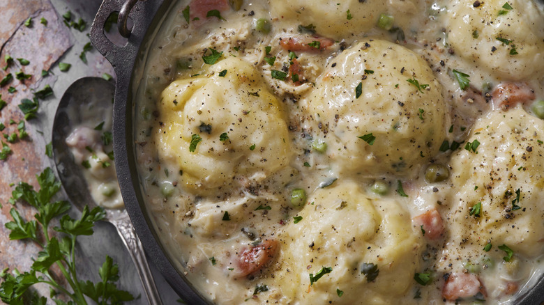 Creamy chicken in a dish topped with fresh herbs