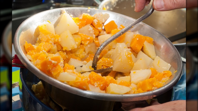 Person using a food mill with potatoes