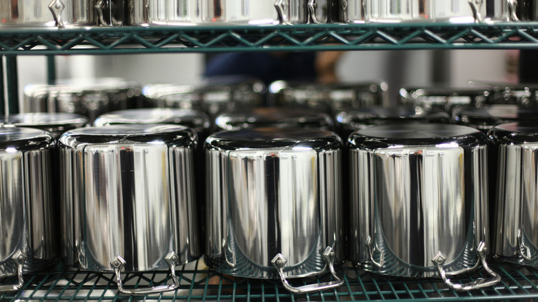All-Clad cookware lined up in professional kitchen