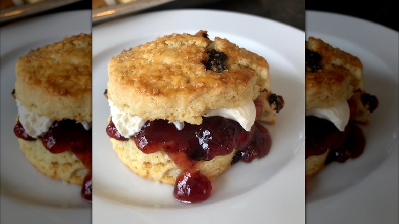 Ina Garten's breakfast scone with jam and cream on a white plate