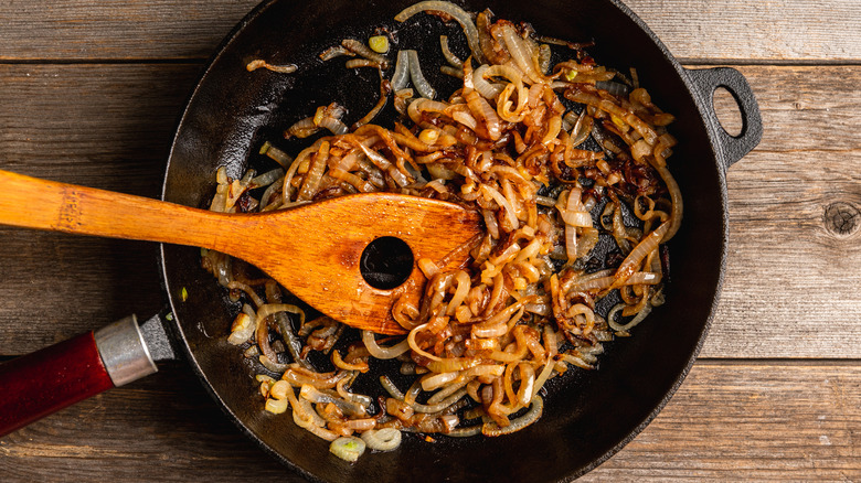 Caramelized onions in skillet with wooden spoon