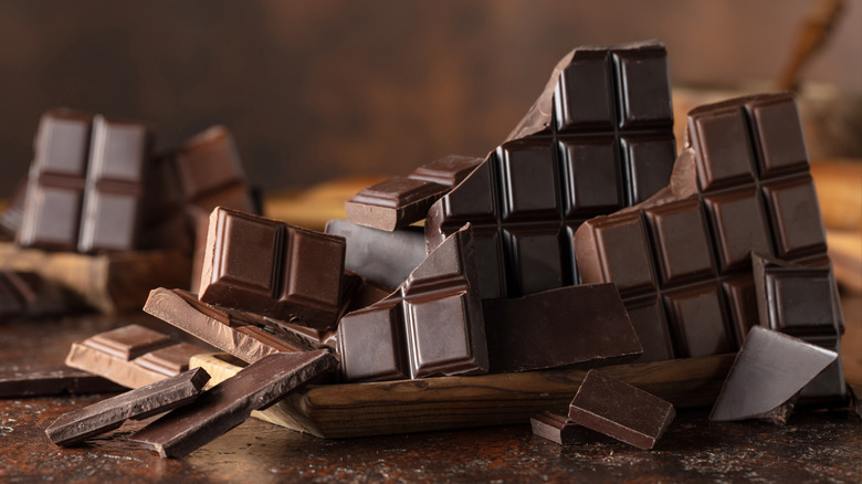 Broken slabs of chocolate on a dark surface.