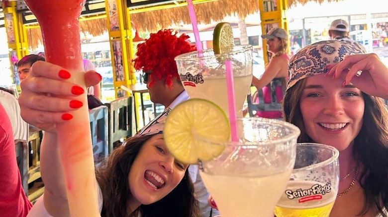 Two young women at Señor Frog's having colorful drinks