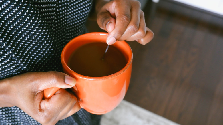 hands stirring a cup of coffee