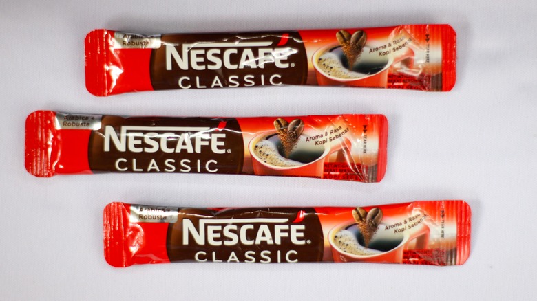 Three packets of Nescafe instant coffee