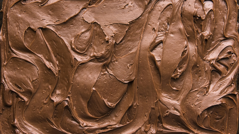 Close up of chocolate icing spread out on a flat surface.