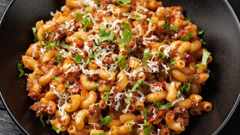 Taco mac and cheese with ground beef in a black bowl