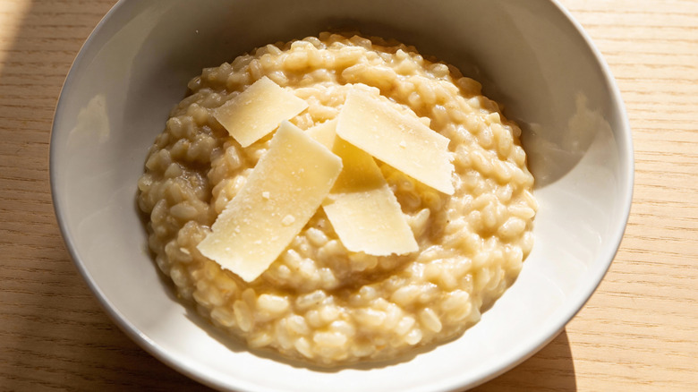 Parmesan shavings top risotto in a bowl