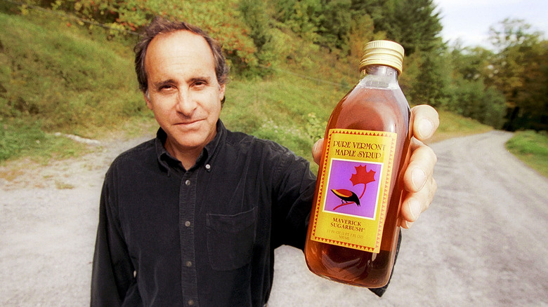 A man holding a bottle of Pure Vermont Maple Syrup