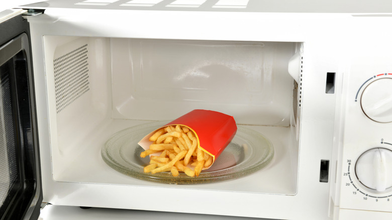 French fry container with fries in the microwave