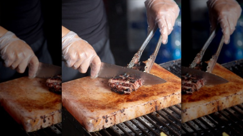 Cutting steak on a Himalayan salt block on the grill