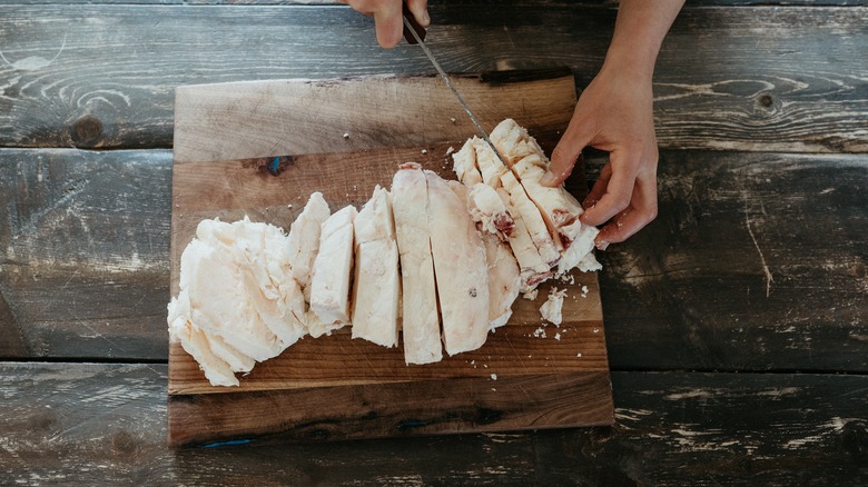 Cutting up beef tallow on a wood cutting board