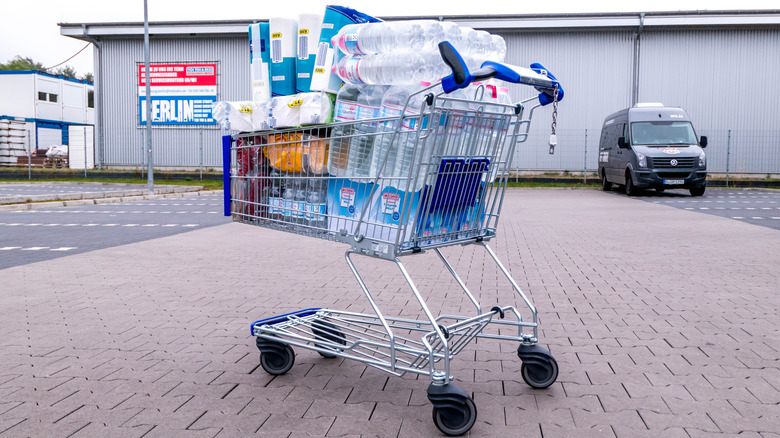 An Aldi shopping cart in a parking lot filled with waters