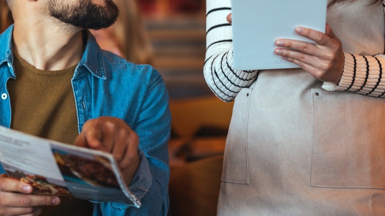 person pointing to restaurant menu