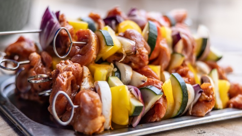 Plate of grilled chicken and vegetable kabobs