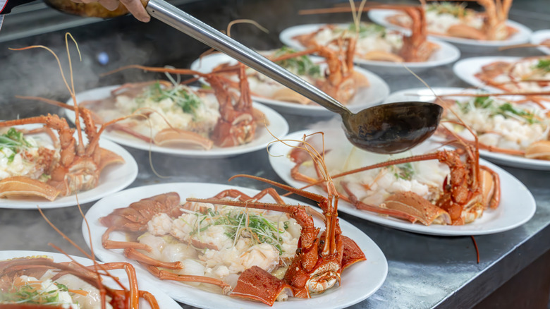 A chef prepares a crab dish on several plates.