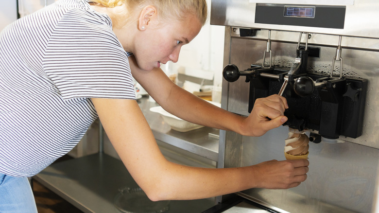 Woman dispensing soft serve ice cream into cone