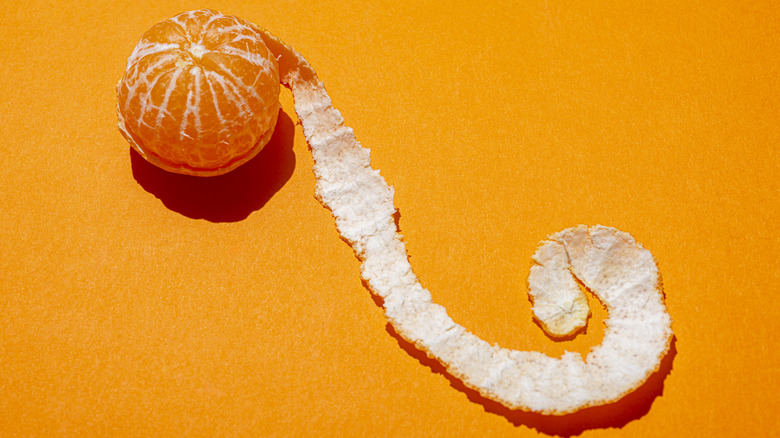 Peel of a mandarin uncoiled around the fruit
