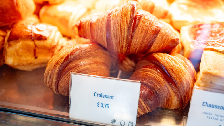 Stack of croissants in a bakery case