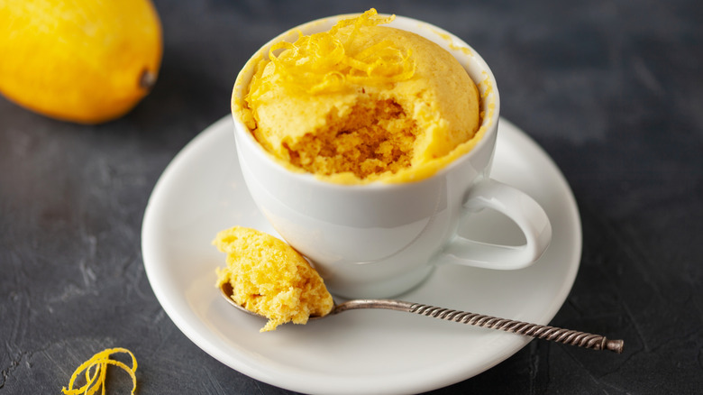 A lemon mug cake with a lemon zest garnish