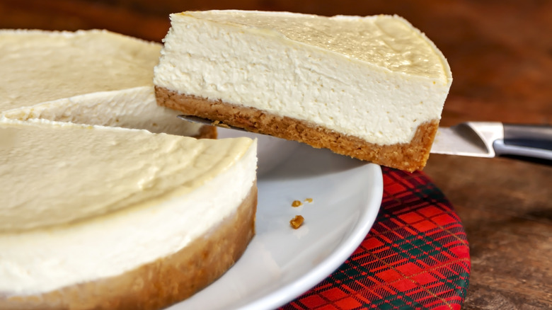 Someone removing a slice of cheescake