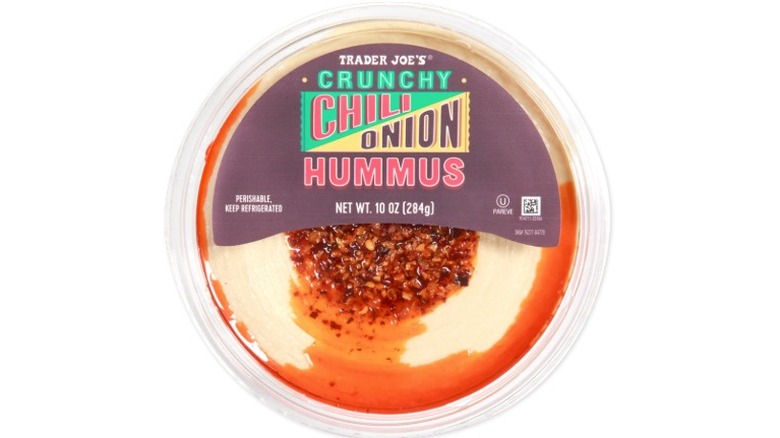 Top view of a plastic container of Trader Joe's Crunchy Chili Onion Hummus on a white background.