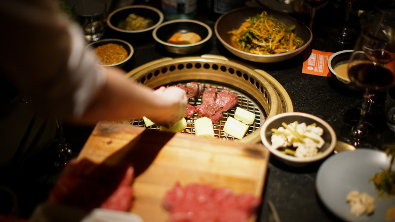 Chef preparing a Korean BBQ spread at Cote Korean Steakhouse NYC
