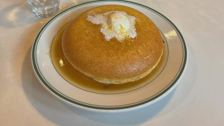 Golden Diner pancakes stacked on white plate with butter melting