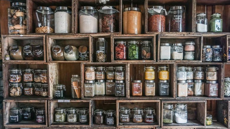wooden shelves full of jars of herbs and spices