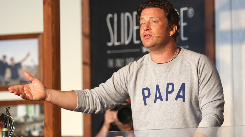 Jamie Oliver attends a cooking demonstration wearing "Papa" sweatshirt