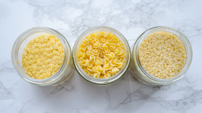 Three glass jars of small dried pasta