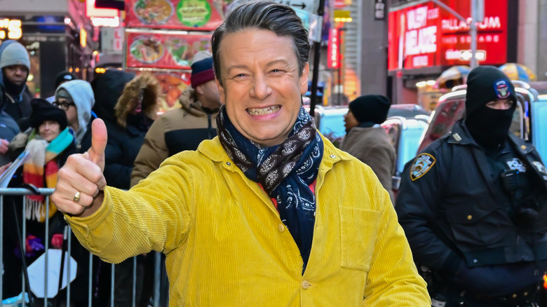 Jamie Oliver in yellow coat giving thumbs up