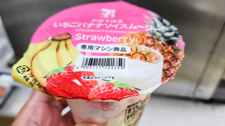 Hand holding a plastic cup of 7-Eleven Japan smoothie