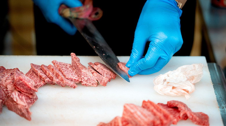 Chef with gloves slicing Japanese wagyu beef