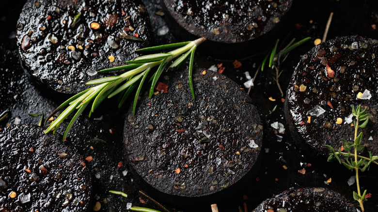A closeup of black pudding sliced and fried with rosemary